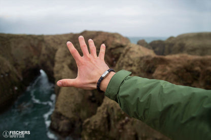 Ausgestreckte Hand Richtung Meer, mit Armband Makrele Segeltau von Fischers Fritze