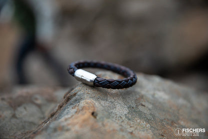 Armband Leder in Kombination mit gewachster Baumwolle liegt geschlossen auf Felsenklippe