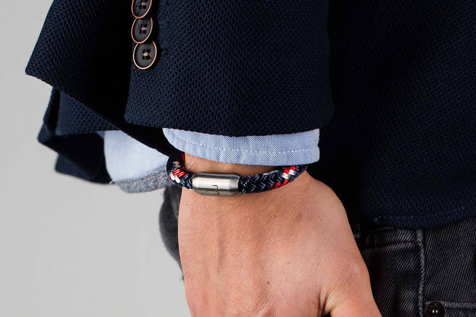 Angelegt an Handgelenk, das maritime Fischers Fritze-Armband aus Segelseil, Makrele marineblau rot weiss, Angelhaken Gravur